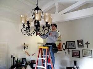 Electrician installing chandelear