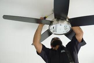 Electrician installing ceiling fan